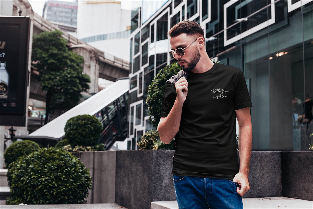Bitte Wein einfüllen – Herren-T-Shirt in Schwarz mit kleinem weißem Brustprint, draußen getragen