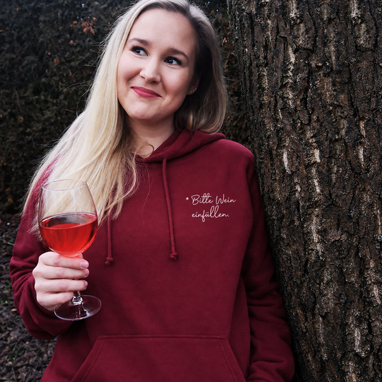 Bitte Wein einfüllen – Unisex-Hoodie in Bordeaux mit kleinem weißem Brustprint, draußen getragen