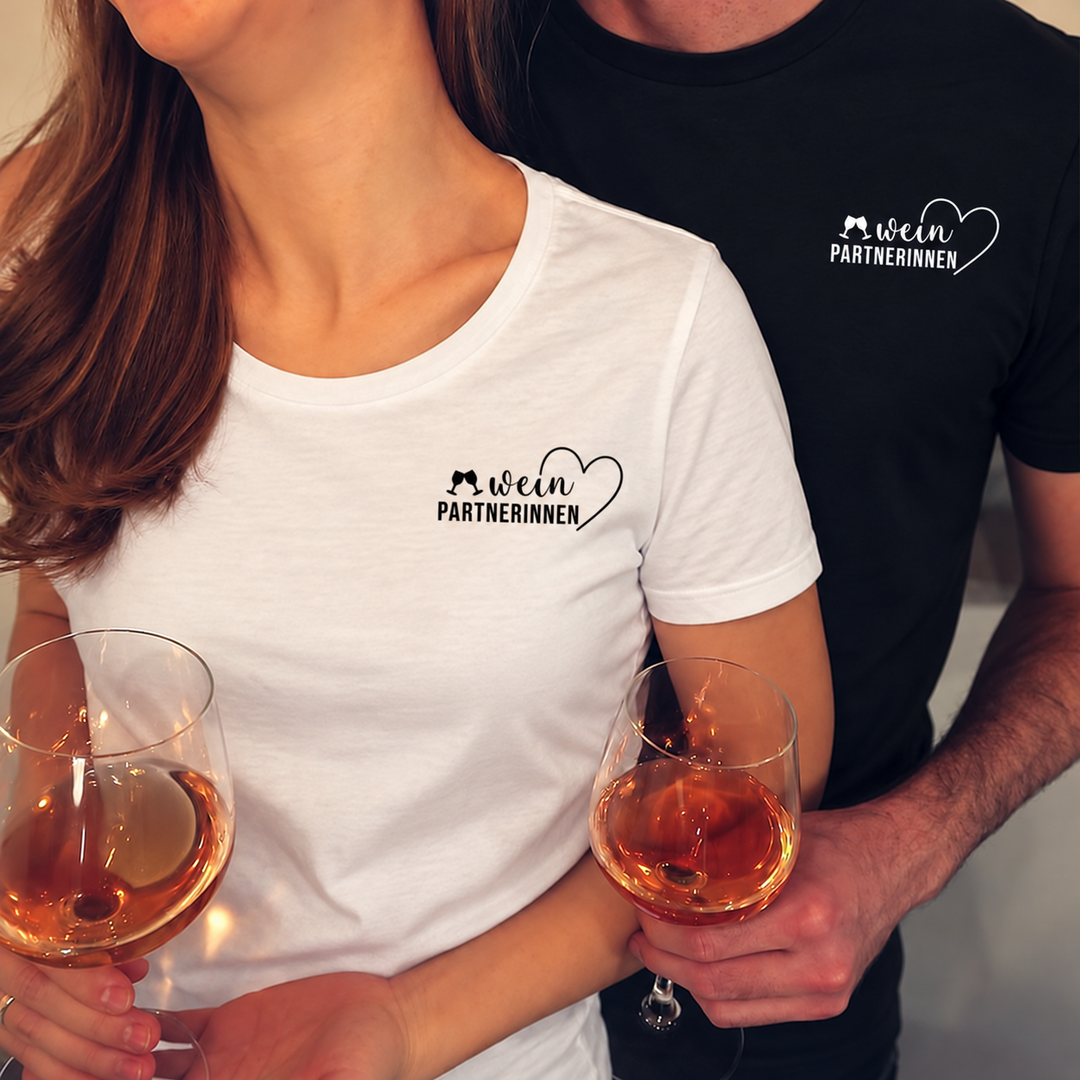 Digital bearbeitete Paaraufnahme mit Weinpartnerinnen-Motiv: Herren-Shirt schwarz mit weißem Druck, Damen-Shirt weiß mit schwarzem Druck; Shirts separat erhältlich.